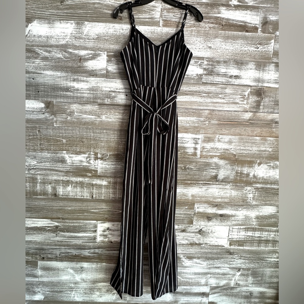 Women’s jumpsuit, black with white pin stripes, and spaghetti straps.